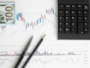 A financial graph under a calculator and money.