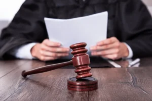 A judge reading a paper with a gravel in the foreground.