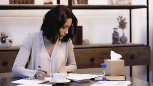 A woman sits at her desk while looking over divorce paperwork.