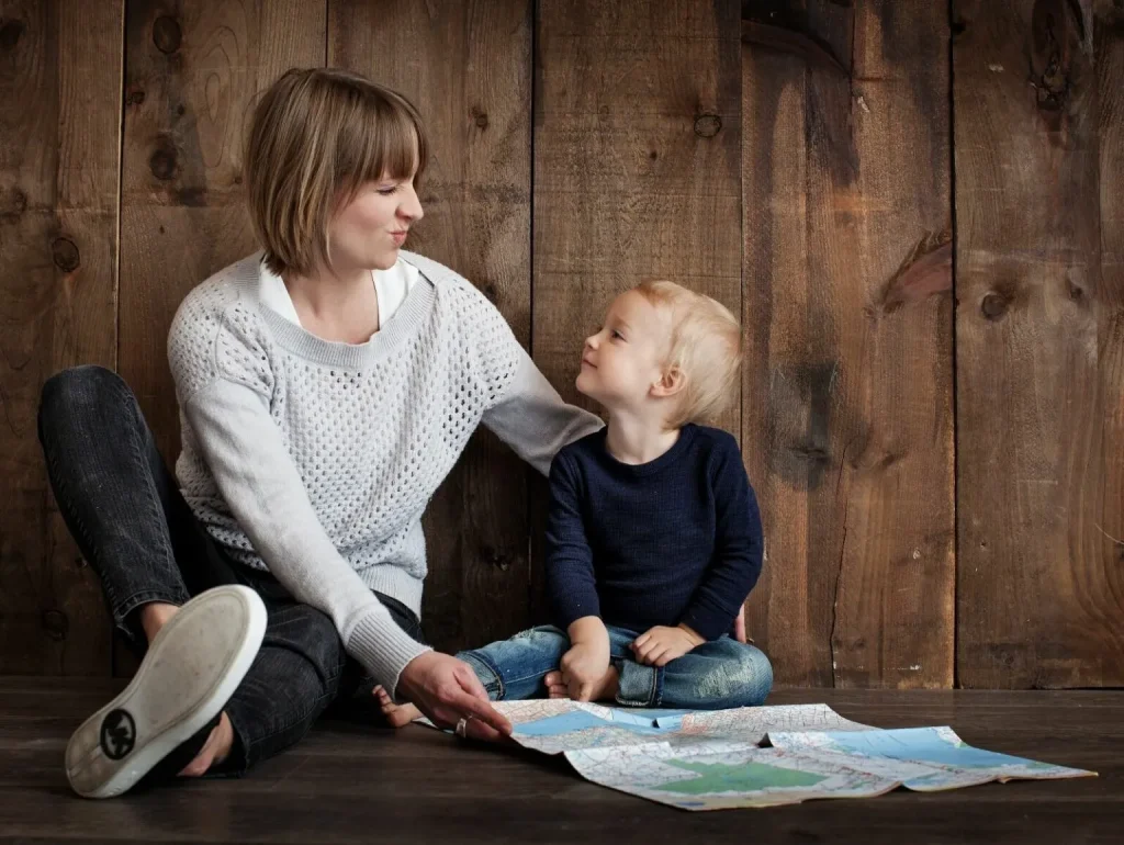 A mother and child playfully looking at a map.