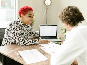 A woman looking happy ad she discusses her prenup with her divorce lawyer.