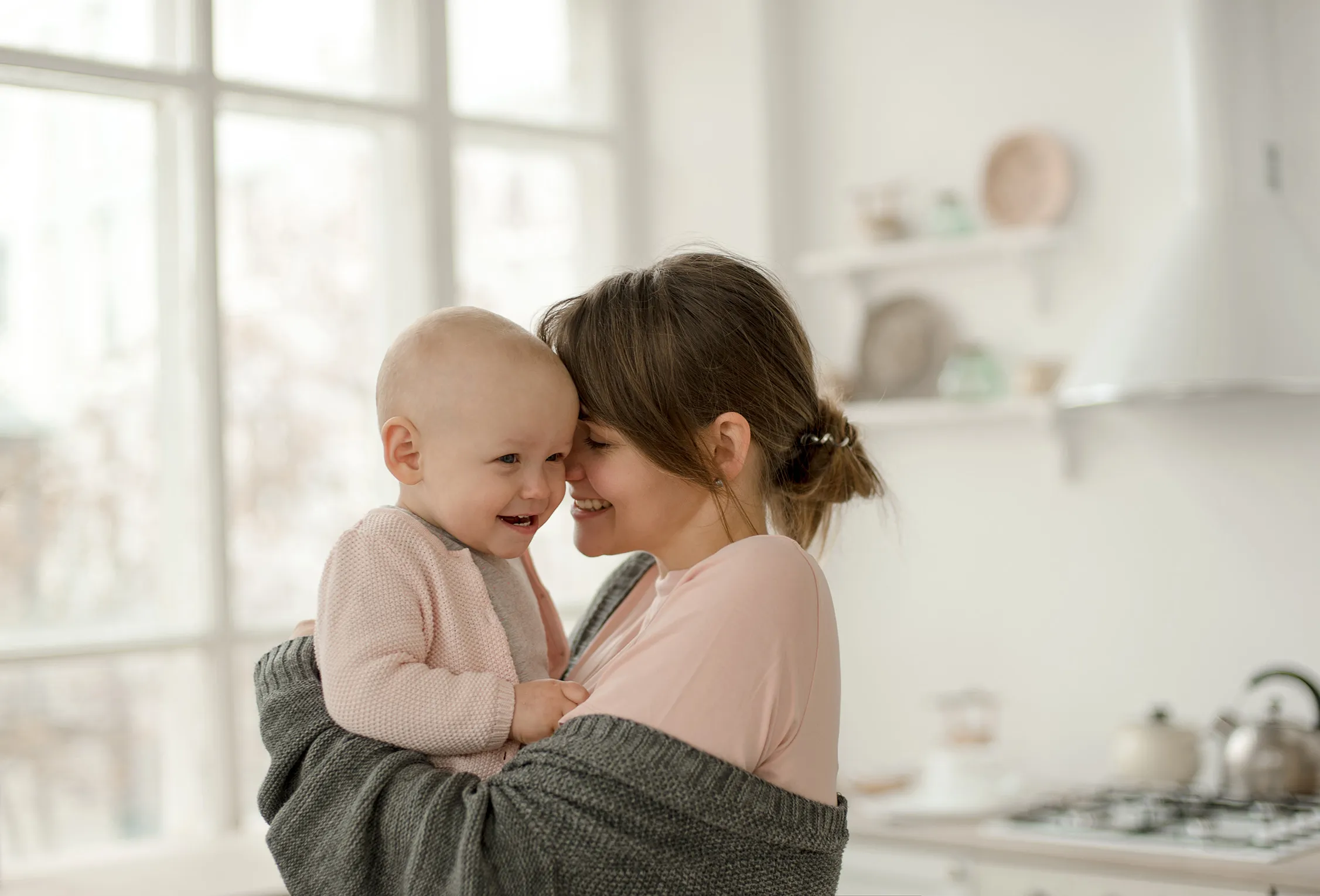 Young mom smiling and hugging baby at home. We know that there is nothing more precious than your child, that’s why the women divorce attorneys at Woodford Sathappan Mcgee will fight to the end for a favorable child custody result. 