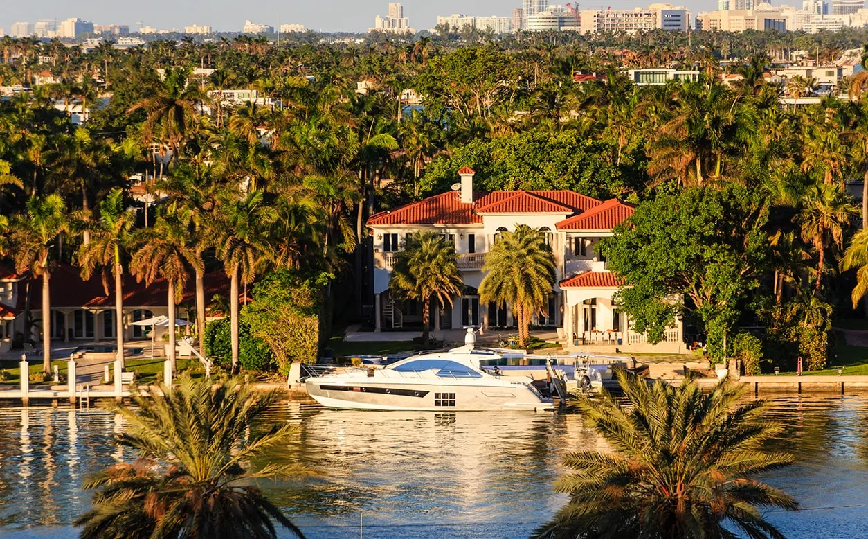 Mansion and boat on the waterfront in a tropical climate. Our female divorce lawyers can ensure that you’re getting what you deserve in your high asset divorce. 