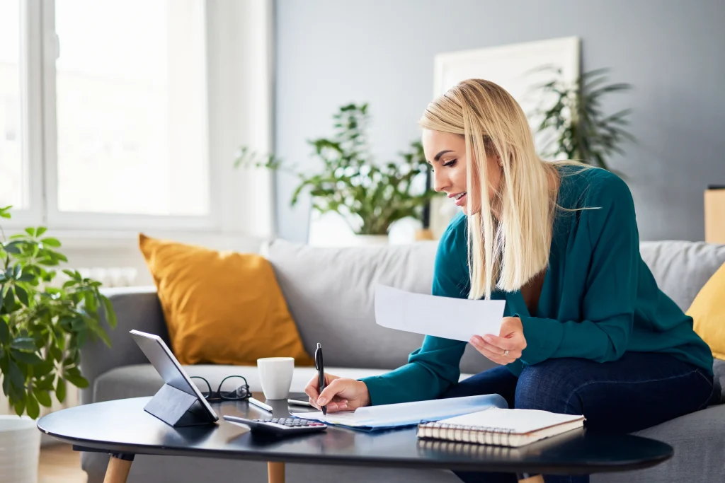 A woman sitting at table doing finances.