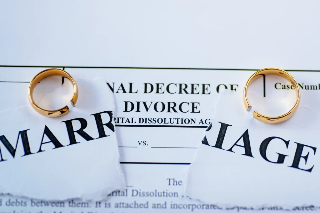 Broken wedding bands sitting on top of divorce paperwork.