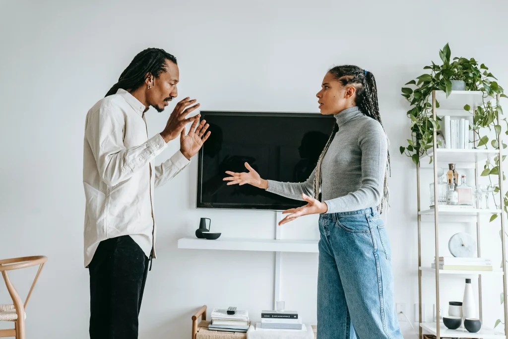 A couple looking upset and arguing with their hands in the air.