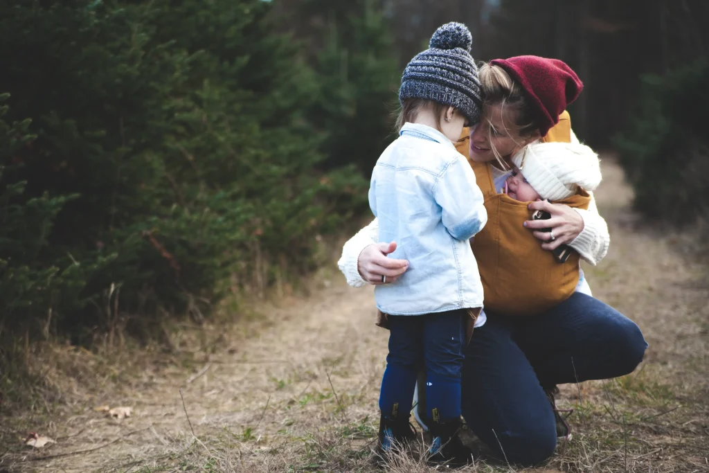 A mom hiking with her two kids during fall.