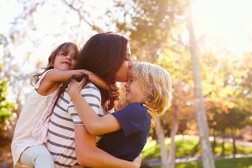 A mom hugging her son and daughter.