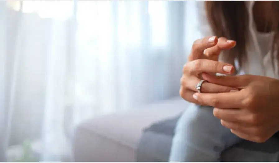 A woman removing her wedding ring.