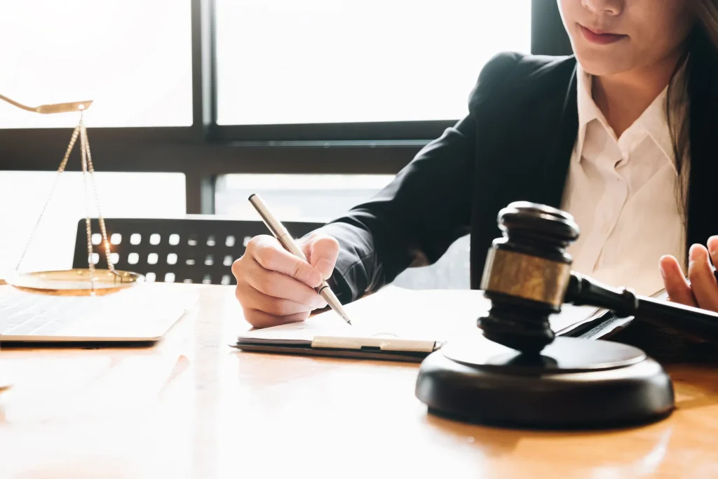 An attorney is working at her desk with a gavel in front of her.