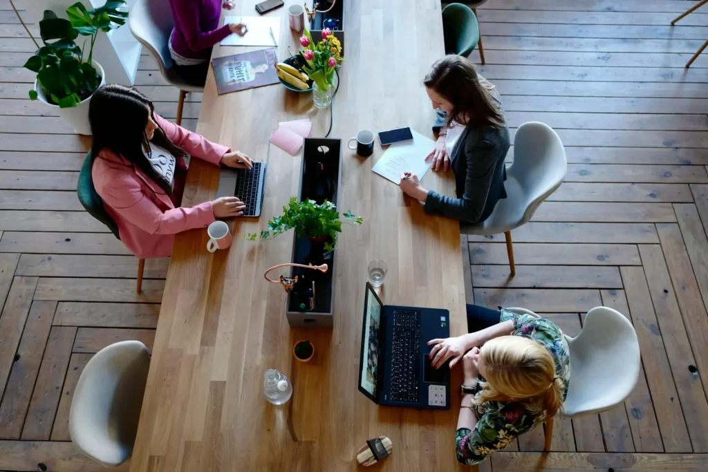 A group of attorneys working on their laptops at a long table.