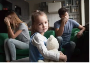 Two parents fighting and a sad child.