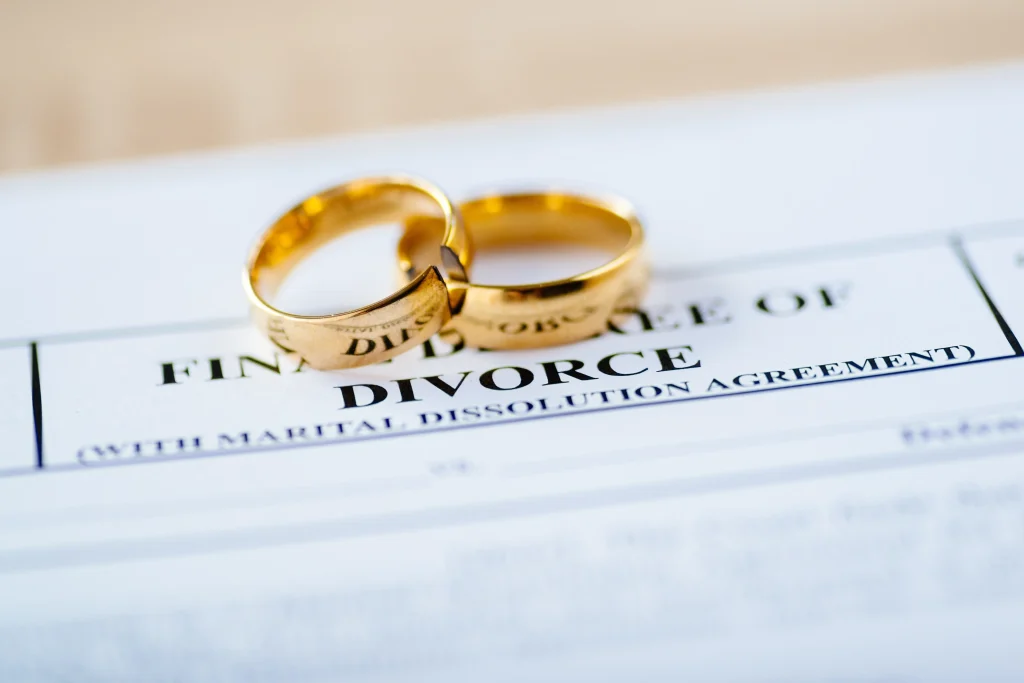 Divorce paperwork with wedding rings on it. 