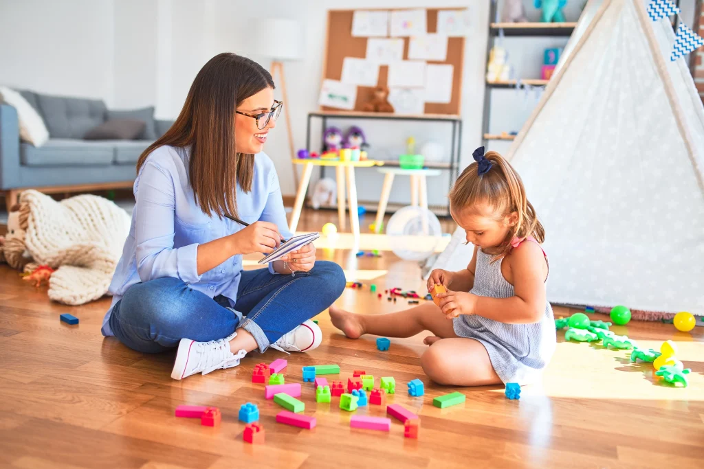 A mom playing on the floor with her daughter.