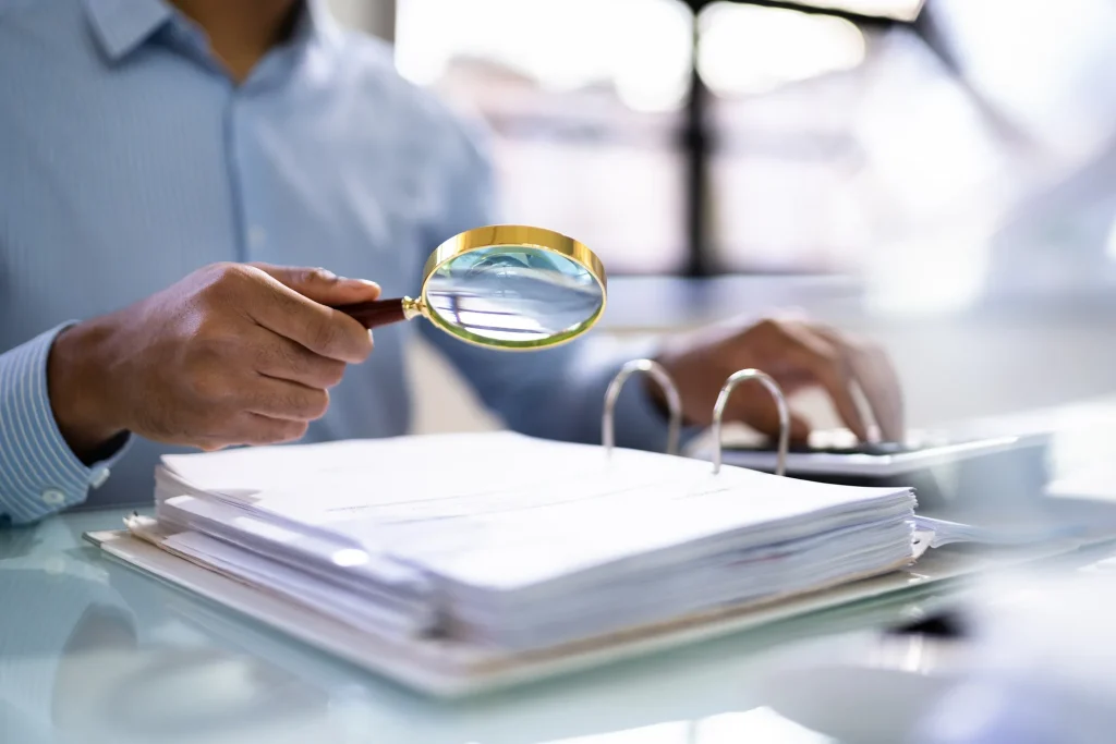 Lawyer using a magnifying glass over a large book.