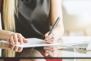 Women signing legal documents.