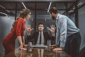 A couple arguing in front of a lawyer in a meeting.