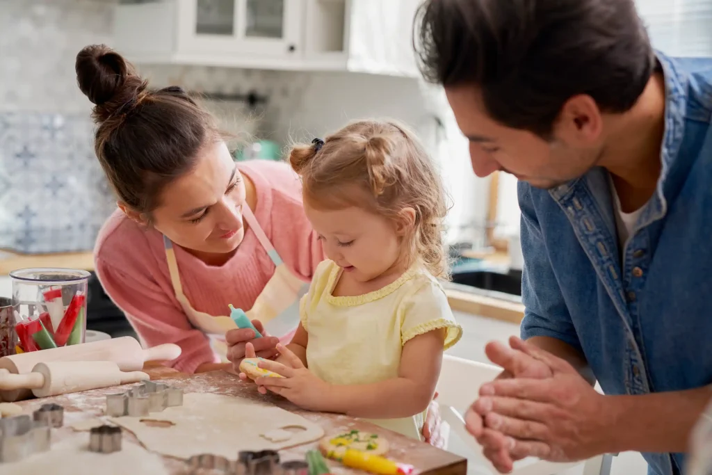 A child baking cookies with her parents.