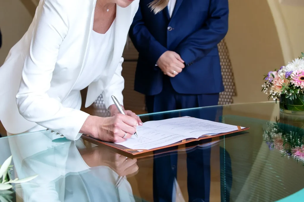 Woman signing divorce papers during legal process.