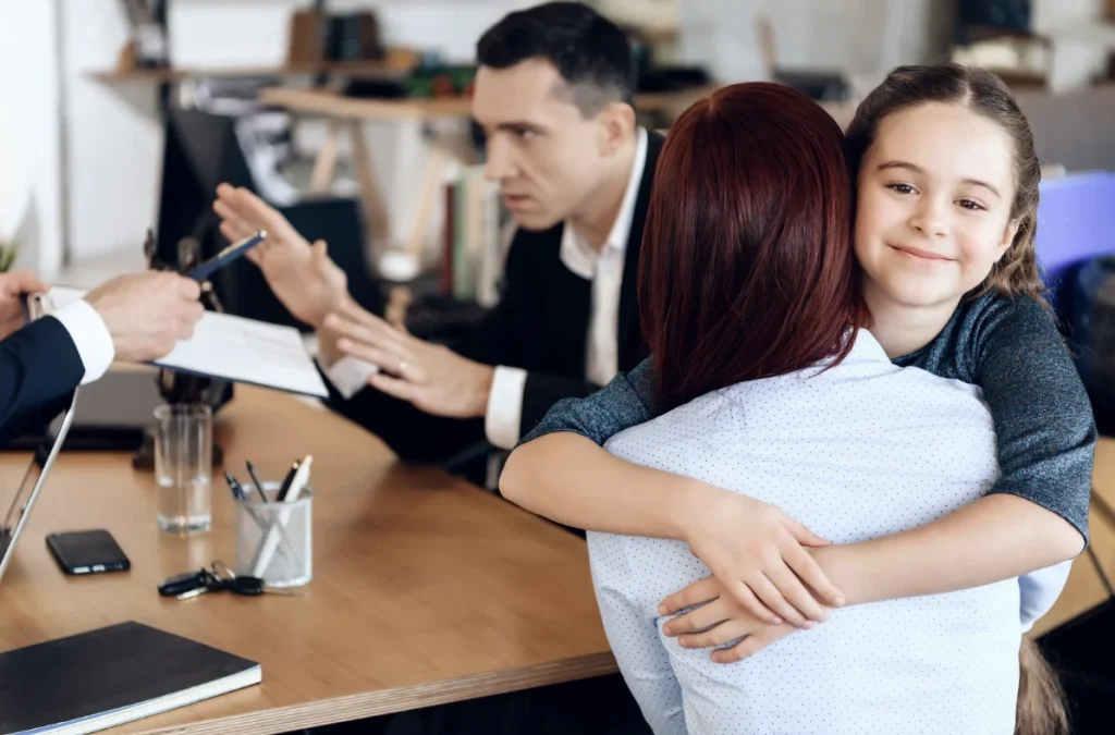 Mother and daughter hug during child custody meeting.