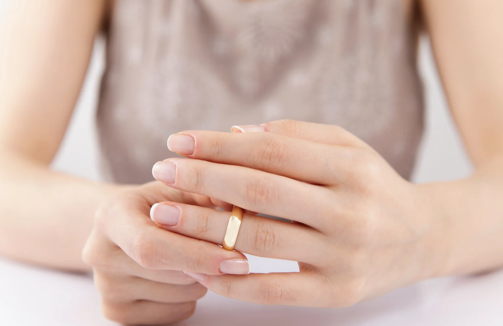 Woman removes a marriage ring.
