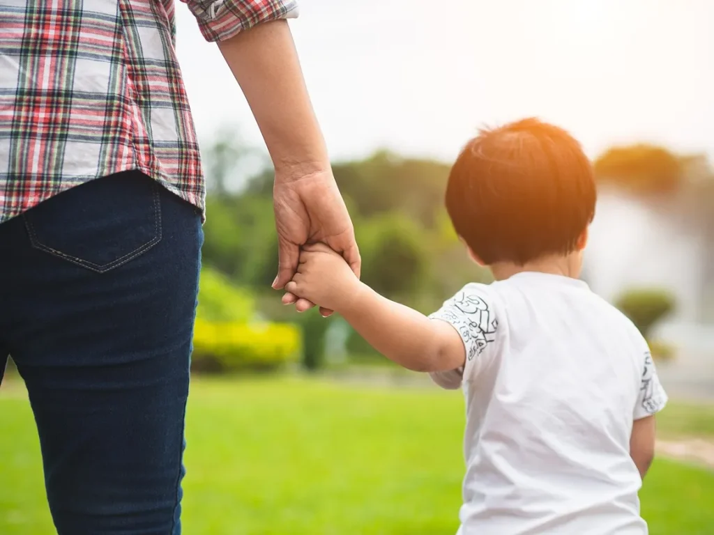 A mom holding her son's hand.